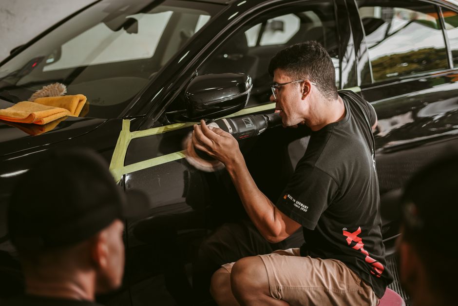 Professional auto detailer working on a vehicle exterior